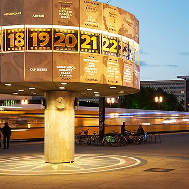 Tiny bird with pale brown, orange and white feathers in an evergreen tree.