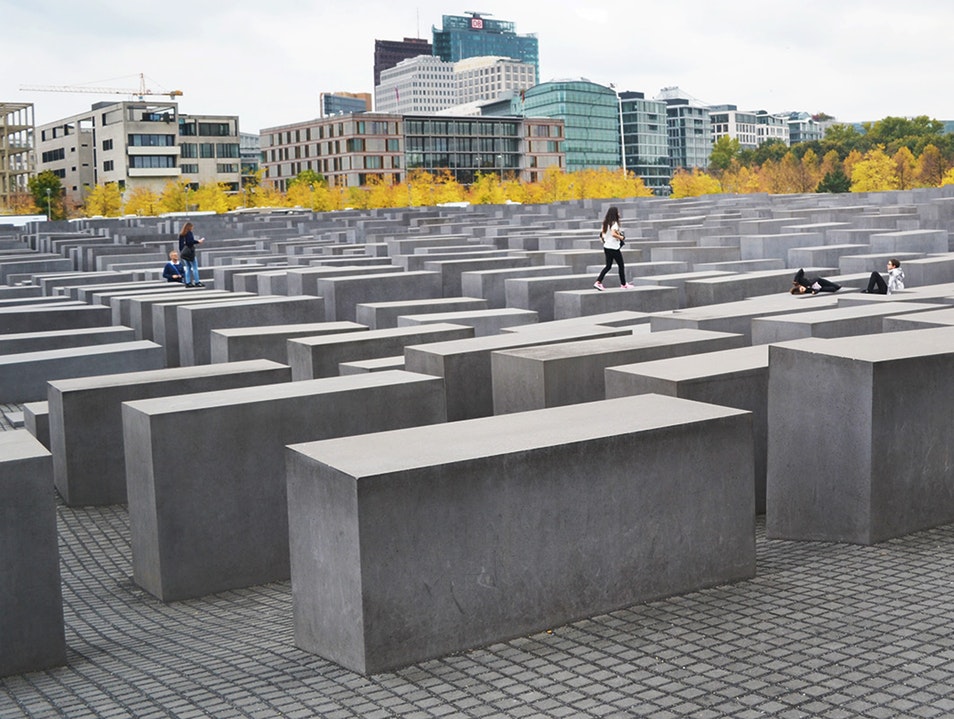 Tiny bird with pale brown, orange and white feathers in an evergreen tree.
