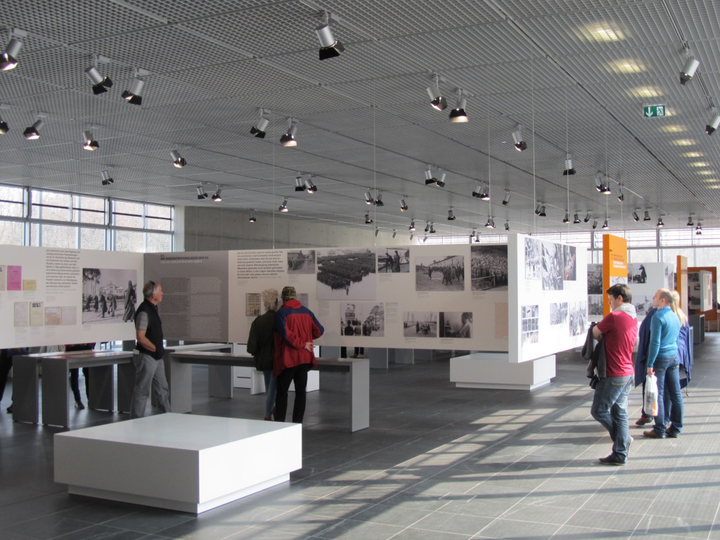Tiny bird with pale brown, orange and white feathers in an evergreen tree.