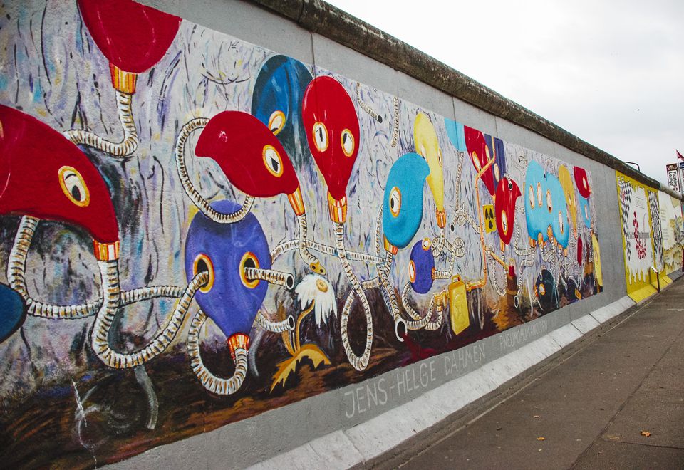 Tiny bird with pale brown, orange and white feathers in an evergreen tree.
